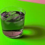 close-up of chlorophyll vodka soda drink on a pink and green background in honor of the movie 'Wicked'