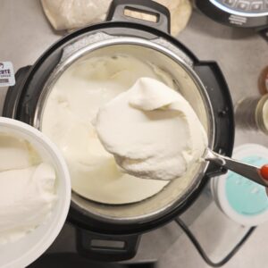 Image of hand spooning freshly made yogurt from Instantpot into storage container. Photo by Charles Malene for MoodyEater™