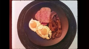 MoodyEater makes... Succession's Prison Breakfast of bacon, fried eggs and hash browns. Image is treated with a vintage camera effect