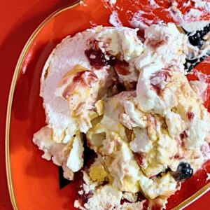 Partially eaten Pavlova Meringue Eton Mess, covered in persimmon jam, mixed berry compote, lemon curd, vegan lemon curd, whipped cream, fresh raspberries, fresh blueberries and zabaglione cream on Jonathan Adler 'Lips' Trinket Tray. Photo by Charles Malene for MoodyEater™