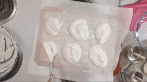 6 small Pavlova Meringue spooned onto parchment covered baking tray. Photo by Charles Malene for MoodyEater™
