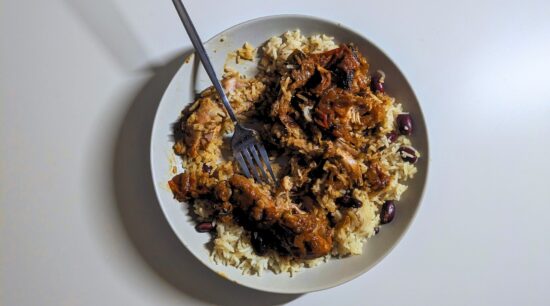 Brown Stewed Chicken on Rice and Peas partially eaten. Photo by Charles Malene for MoodyEater™