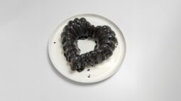 Jet Black Velvet Cocoa chocolate cake, in the shape of a heart, covered in black sugar glaze, on a white plate. Photo by Charles Malene for MoodyEater™