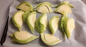 Cabbage cut into wedges on parchment lined baking tray. Photo by Charles Malene for MoodyEater™