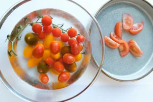 Tomato medley soaking in cold water and on plate. Photo by Charles Malene for MoodyEater™